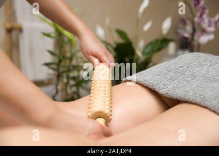 Closeup del massaggio anti-cellulite della maderoterapia con massaggiatore a rulli in legno Foto Stock