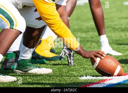Un centro di calcio della scuola superiore è allineato e pronto a scattare la palla per iniziare il gioco. Foto Stock
