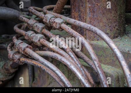 Tubazioni idrauliche arrugginite su una vecchia macchina. Foto Stock