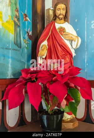 Kalapana, Hawaii, Stati Uniti. - 14 Gennaio 2020: Maria, Stella Del Mare Chiesa Cattolica. Primo piano della statua di Gesù Sacro Cuore con abito bianco e rosso dietro Foto Stock