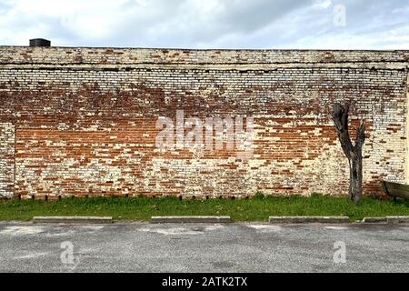 un vecchio edificio in mattoni rossi con un parcheggio vuoto Foto Stock