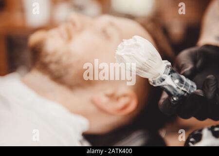 Spazzola per barba e ciotola, sfondo sfocato del parrucchiere per uomini, barbiere Foto Stock