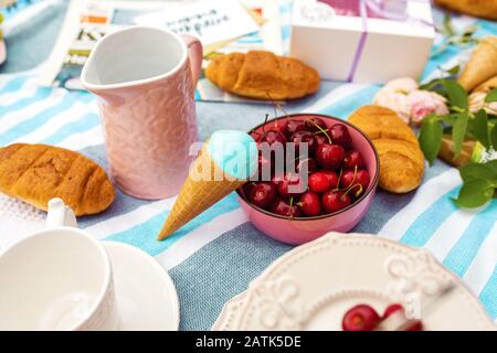 Picnic estivo con ciliegie mature e gelato. Foto Stock
