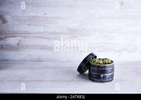 Marijuana ricreativa e macinacaffè di metallo su uno sfondo di pietra bianca dopo che l'Illinois passa una legge per legalizzare le vendite di erbacce e la prigione di disperdono relativo alle erbacce Foto Stock