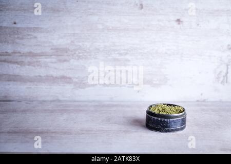Marijuana ricreativa e macinacaffè di metallo su uno sfondo di pietra bianca dopo che l'Illinois passa una legge per legalizzare le vendite di erbacce e la prigione di disperdono relativo alle erbacce Foto Stock