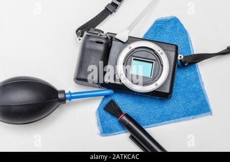 Servizio di fotocamera digitale professionale. Corpo della fotocamera digitale e strumenti per la rimozione della polvere: Spazzola, ventola dell'aria e mop. Foto Stock