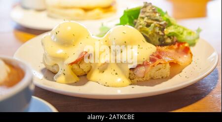 Uova Selettive Focalizzate Benedict, un panino consiste di 2 metà di muffin inglesi conditi con uovo in camicia, pancetta o prosciutto e salsa hollandaise. Americ Foto Stock