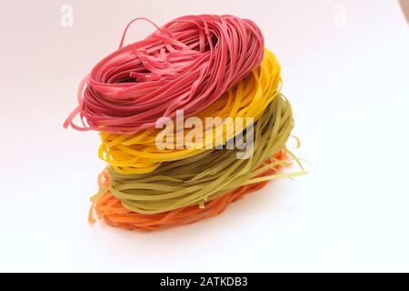 Spaghetti colorati isolati nidi su sfondo bianco. Foto Stock