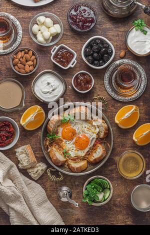 Deliziosa colazione turca con uova, olive, formaggio, cetrioli, marmellata e yogurt, piatto Foto Stock