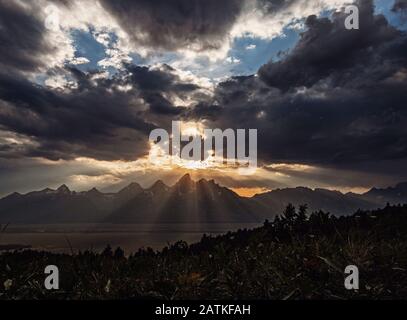 Il sole tramonta attraverso le nuvole sulle montagne Teton, Wyoming Foto Stock