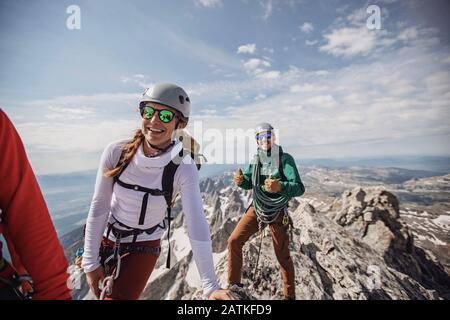 Tre scalatori di roccia sorridono dopo aver raggiunto la vetta del Grand Teton Foto Stock