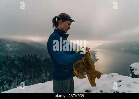 Una giovane donna si trova in cima ad un punto nevoso nella Columbia Gorge Foto Stock