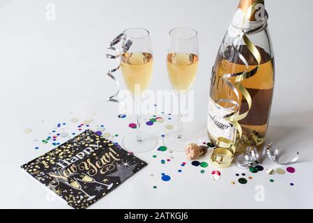 Due bicchieri e una bottiglia di champagne su sfondo bianco. Foto Stock