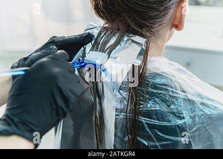 donna che ha capelli invelati mentre colorano in un salone di capelli Foto Stock