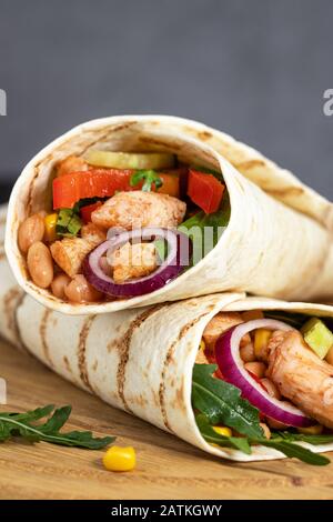 Burritos avvolge con pollo e verdure su sfondo scuro. Cibo messicano. Foto Stock