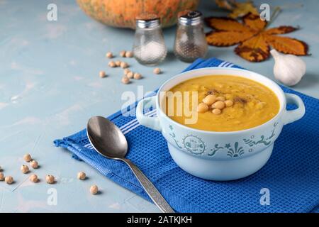 Autunno vegetariano Crema di zucca minestra di ceci su fondo azzurro, Primo Piano Foto Stock