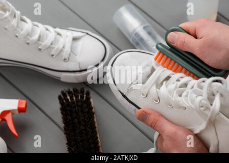 Scarpe da ginnastica bianche da uomo su sfondo grigio Foto Stock