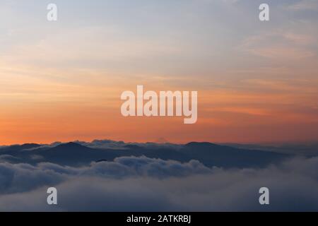 Tramonto con cielo colorato e molte nuvole sopra le montagne - Vulcano Atitlan sfondo Foto Stock