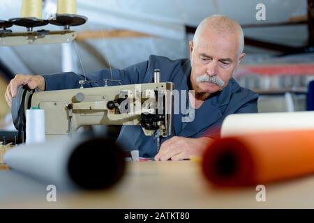 Senior uomo al lavoro in fabbrica Foto Stock