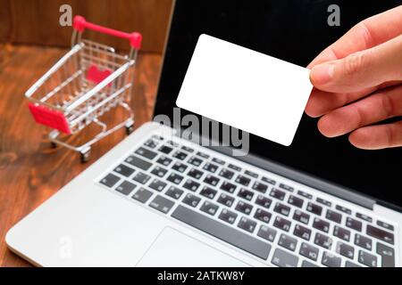 Shopping su Internet. Computer portatile con piccolo carrello sul tavolo,  primo piano Foto stock - Alamy