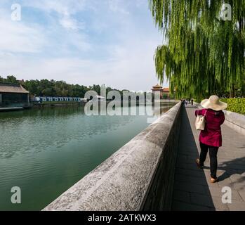 Donna in cappello di paglia a testa larga, a piedi da Palace Moat, Città Proibita, Pechino, Cina, Asia Foto Stock