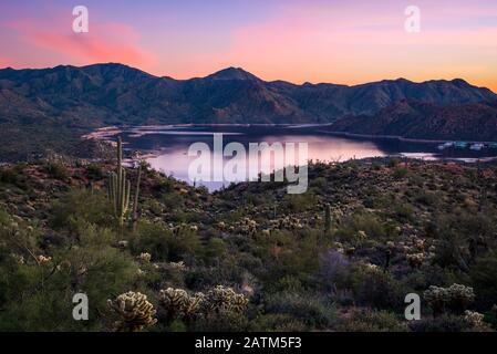 Vista panoramica del lago Bartlett al crepuscolo con sfumature viola che colorano l'acqua e il paesaggio desertico. Foto Stock