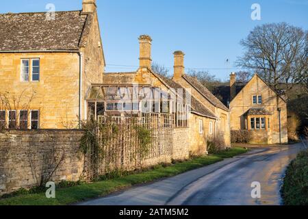 Cotswold case in pietra nel pomeriggio tramonto luce invernale. Wood Stanway, Cotswolds, Gloucestershire, Inghilterra Foto Stock