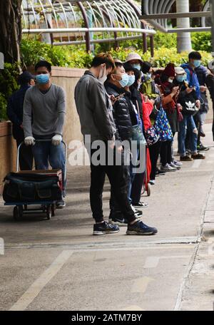 Hong Kongers locale in coda per maschere chirurgiche durante l'epidemia di Coronavirus di Wuhan. Foto Stock