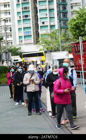 Hong Kongers locale in coda per maschere chirurgiche durante l'epidemia di Coronavirus di Wuhan. Foto Stock