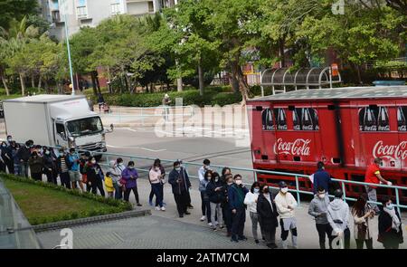 Hong Kongers locale in coda per maschere chirurgiche durante l'epidemia di Coronavirus di Wuhan. Foto Stock