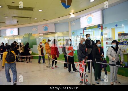 Hong Kongers locale in coda per maschere chirurgiche durante l'epidemia di Coronavirus di Wuhan. Foto Stock