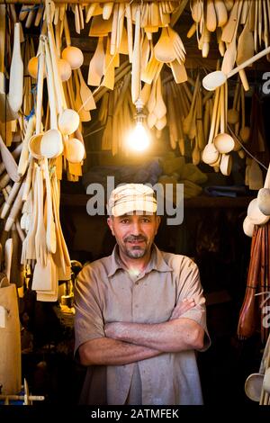 Ritratto di un artigiano di posate di legno nella sua bottega di mercato medina a Marrakech, Marocco Foto Stock