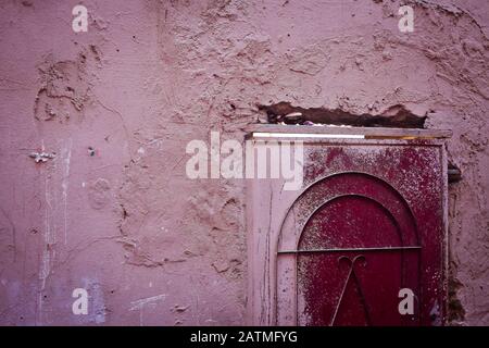 Vernice da un muro trabocca su una porta a Marrakech, Marocco Foto Stock