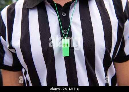 Arbitro calcio con fischio di plastica verde. Primo piano. Fischio intorno al collo di qualcuno. Foto Stock