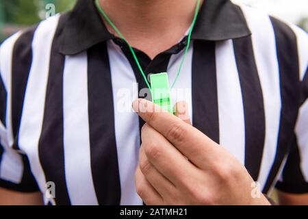 Allenatore di calcio arbitro tenere fischio a portata di mano Foto Stock