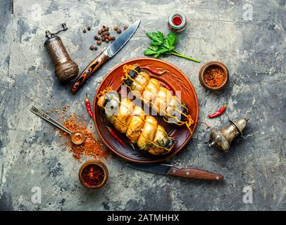 Rullo di pesce appetitoso fatto da sgombro affumicato. Pesce affumicato caldo. Foto Stock