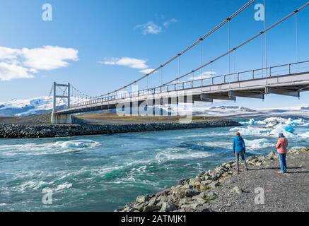 Panorama di un ponte sul ghiacciaio di Jokulsarlon e iceberg che galleggiano nel fiume, uno dei luoghi più turistici in Islanda. Foto Stock