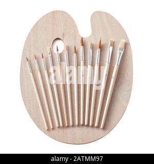 Nuova tavolozza d'arte della pittura in legno con una serie di pennelli per pittura isolati su bianco Foto Stock