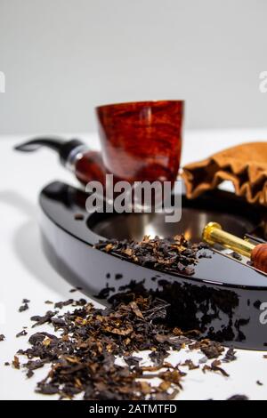 tabacco sparso sopra e davanti al posacenere Foto Stock