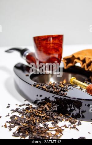 tabacco sparso sopra e davanti al posacenere Foto Stock