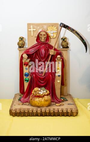Una statua rossa di Santa Muerte esposta in un tempio di casa a Jackson Heights, Queens, New York City. Foto Stock