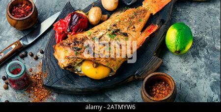 Spigola rossa al forno con funghi e pepe rosso.Pesce in verdure arrostite Foto Stock