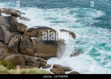 Onde schiaccianti su enormi massi. Potere della natura sfondo Foto Stock