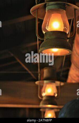 Colpo verso l'alto di luci d'olio vintage illuminate sfumature con lampadine all'interno Foto Stock