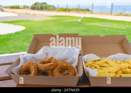 Togliere, togliere il pesce e patatine sul tavolo da picnic. Fast food all'aperto. Australia Foto Stock