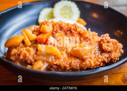 Croccante cotoletta di maiale fritte con curry e riso al ristorante. Foto Stock
