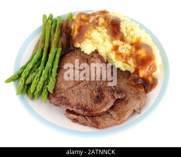 Pasto di carne di cervo fritto con purè di patate e asparagi isolati su uno sfondo bianco Foto Stock