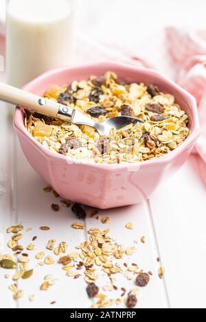 Colazione a base di cereali sani. Muesli misti in ciotola su tavolo bianco. Foto Stock