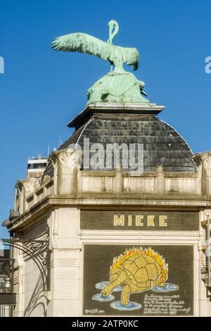 Statua di un pellicano e un mosaico di una tartaruga su una colonna all'ingresso dello zoo di Anversa, Belgio Foto Stock