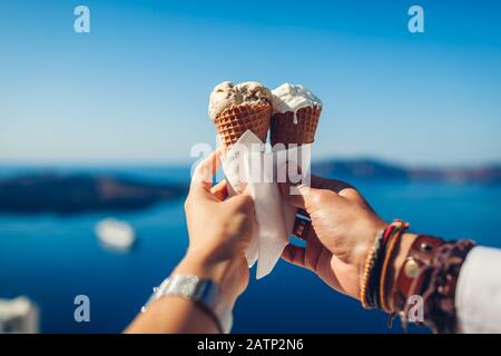 Gelato in coni. Coppia mangiare gelato che lo tiene su sfondo mare. Dolce gustoso cibo estivo. Primo piano Foto Stock